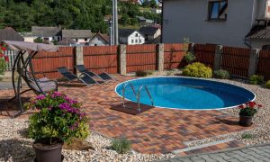Small round backyard pool with patio seating