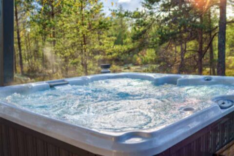 Steaming outdoor hot tub surrounded by trees