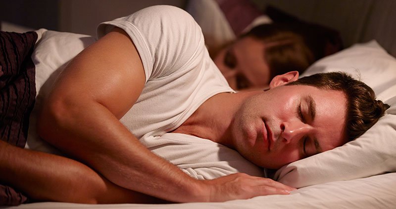 Person lying in bed on their side.