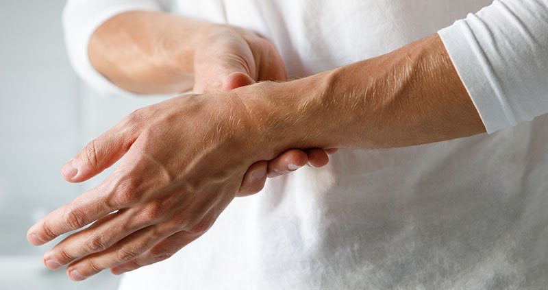 Close-up of hands holding a wrist.