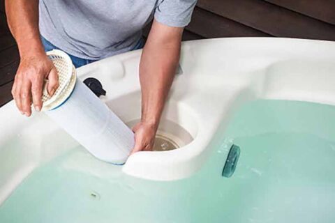 person cleaning hot tub filter