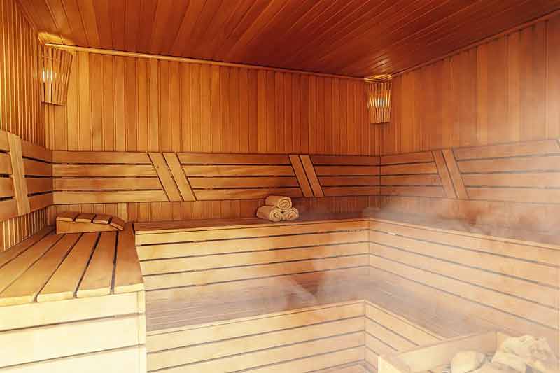 Wooden sauna interior with benches and rising steam