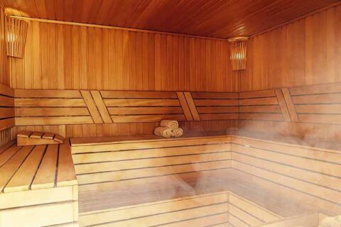 Wooden sauna interior with benches and rising steam