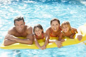 Family floating together on a yellow pool raft