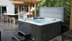 Outdoor hot tub with its cover open on a patio