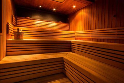 Interior wooden sauna with tiered seating and warm lighting