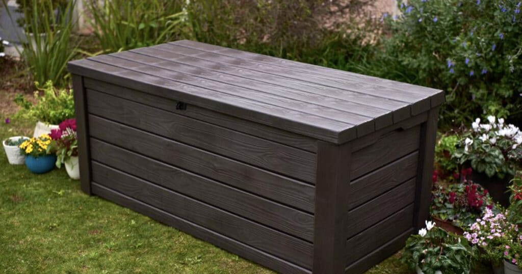 Outdoor storage deck box surrounded by garden plants