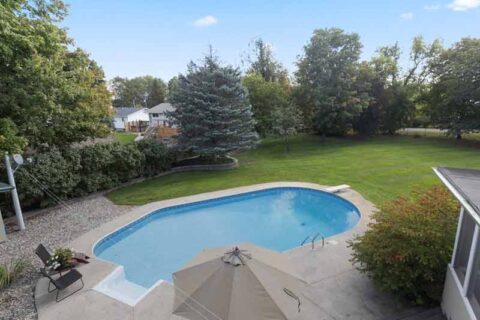 Backyard with an inground pool and surrounding lawn