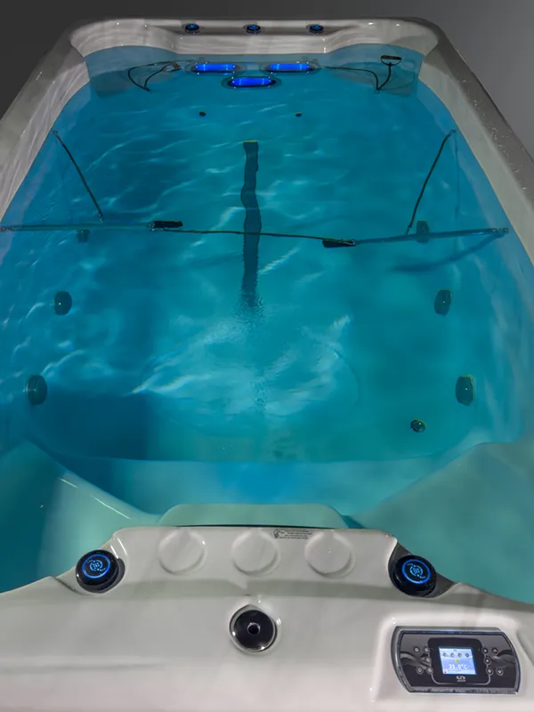 Be Well Canada swim spa filled with water and lights turned on