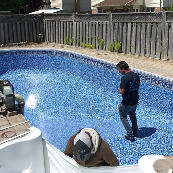 Bliss Home Leisure technicians installing vinyl liner in in-ground backyard pool